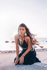 Fototapeta na wymiar beautiful young fashionable woman on the beach at sunset