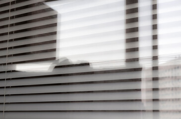 Horizontal white blinds block out the sunlight.