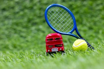 Fotobehang Tennis ball with double decker bus or red bus are on green grass © thaninee