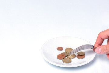 Fototapeta na wymiar Hand holds a fork with euro cent coins on a white plate on a white background, close-up, copy space