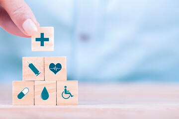 Businessman chooses a emoticon icons healthcare medical symbol on wooden block , Healthcare and...