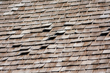 Elevated view of traditional wooden shingle roof with a few damaged shakes