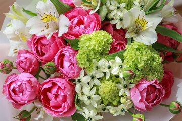 Pink-green bouquet of roses, white lilies, hydrangeas close up