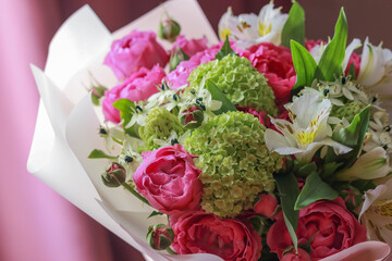 Pink-green bouquet of roses, white lilies, hydrangeas on a purple background