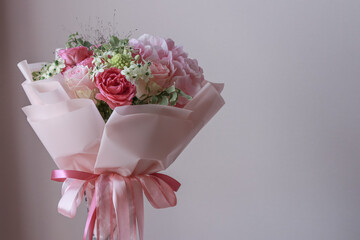 Pink flowers bouquet of roses, hydrangea, green eucalyptus leaves on a light background