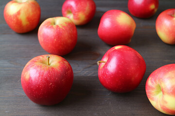 Heap of fresh ripe apples scattered on dark brown wooden background