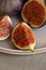 Fresh figs on a plate on a light concrete background