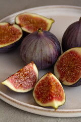 Fresh figs on a plate on a light concrete background