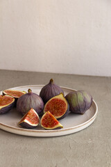 Fresh figs on a plate on a light concrete background