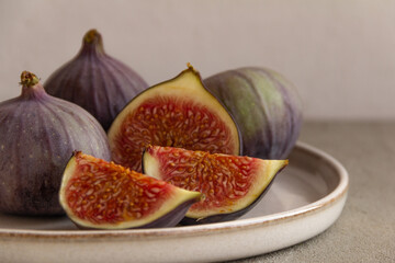Fresh figs on a plate on a light concrete background