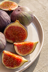 Fresh figs on a plate on a light concrete background