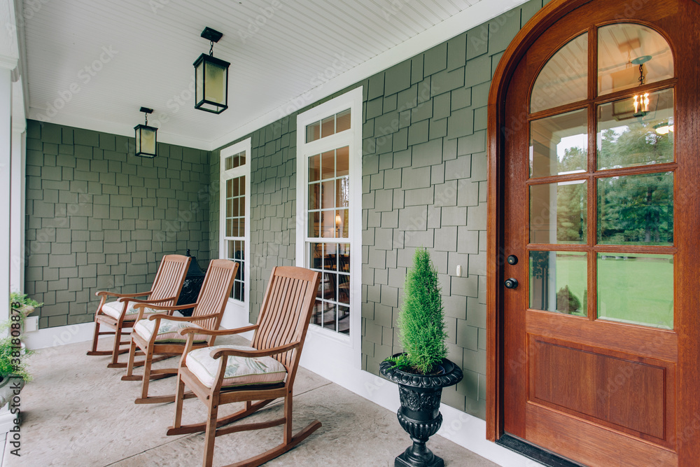 Canvas Prints arch doorway southern covered porch wooden rocking chairs and modern light fixtures with green bush