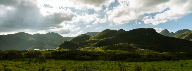 panorama of beautiful countryside. sunny afternoon. wonderful springtime landscape in mountains. grassy field and rolling hills. rural scenery