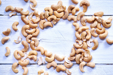Cashew or caju nuts on white wooden background