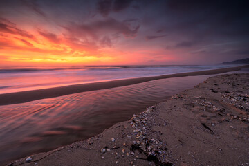 Amazing view with colorful reflections on the beach at sunrise