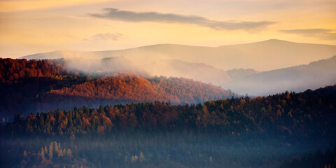 rolling hills in fog at sunrise. beautiful mountain landscape in autumn season. clouds on the morning sky. dramatic nature scenery