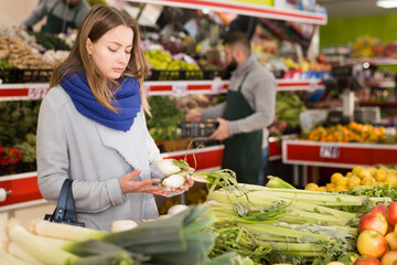 Female shopper picks onions at grocery store. High quality photo