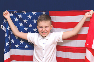 Boy 9s holding big American flag, on blue background
