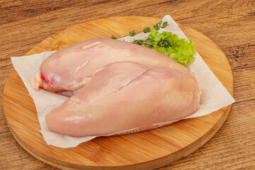 Raw chicken breast over board