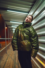 Woman in green jacket standing in metal portal