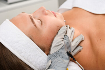 Beautician hands in microcurrent gloves close up