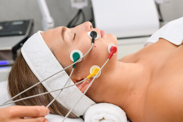 Face myostimulation procedure at beauty spa salon