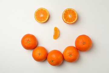 Happy face made of mandarins on white background
