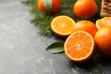 Mandarins, pine branches and basket on gray smoky background