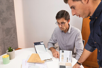 A couple of young male architect working smart from the office elaborating projects and designs. Two young man working on a computer desktop from the office. Architecture concept. Lisbon, Portugal