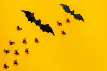 The backdrop for Halloween. On an orange background are black spiders and bats. A place for text.