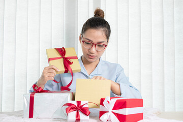 Asian women happy to open surprise boxes are stunned with excitement, joy, and smile on holidays, Christmas, birthday, or Valentine's Day concept
