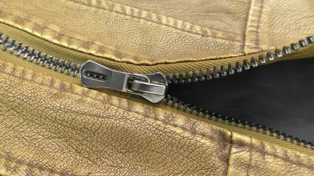 The zipper opens on the brown leather jacket.