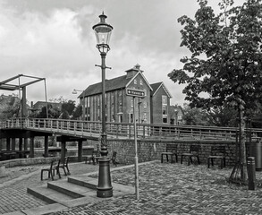 Alter Hafen von Coevorden, die Niederlanden. Schöne alte Kanalhäuser, Laternenpfahl und eine alte Brücke. Schwarzweißbild