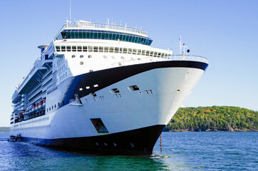 Modern luxury cruiseship or cruise ship liner anchoring on blue sea in bay offshore of Bar Harbor,...