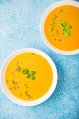 Pumpkin cream soup on a blue background, top view