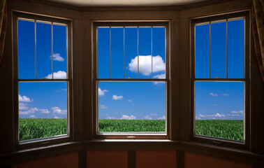 窓から草原と雲