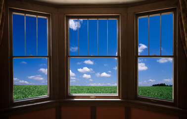 窓から草原と雲