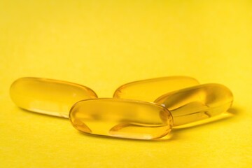 Close-up of Omega-3 capsules isolated on yellow