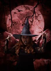 Scary halloween witch with wings standing over cross, church, crow, birds, dead tree, full moon and...