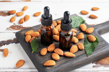 Almond essential oil in dark glass bubbles and fresh almond nuts. Aromatherapy oil natural organic cosmetic.