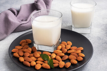 Almond milk in glass glasses on a gray background. Copy space.