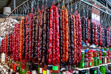 Churchkhela. Traditional Georgian sweets in the form of sausage with grape must, nuts and flour. Oriental sweets, street food. Traditional type of sale of churchkhela in the market