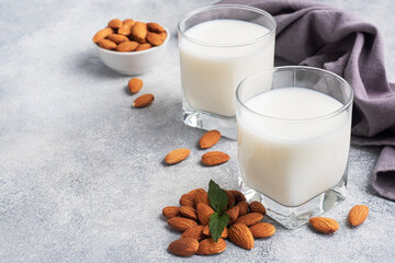 Almond milk in glass glasses on a gray background. Copy space.
