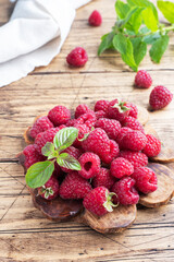 A pile of fresh juicy raspberries on a wooden Board, copy space.