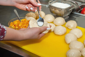 cook puts sugar in the pies. Chef's hands make stuffed pies close-up