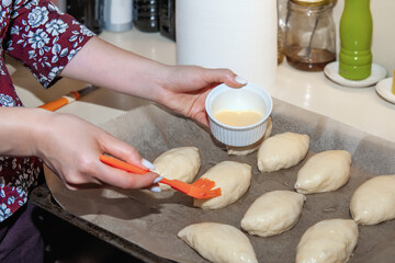 Obraz na płótnie Canvas Smearing egg pie. Preparation of sweet pastries. pies are smeared with egg