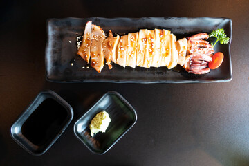 grilled squid with teriyaki sauce on black plate . Japanese seafood . - 381830005