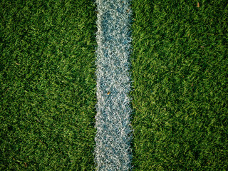 Close up image of white field lines of the penalty area on a football field with synthetic turf....