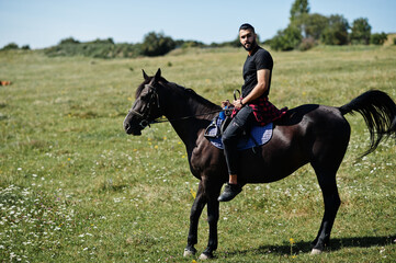 Arab tall beard man wear in black ride arabian horse.