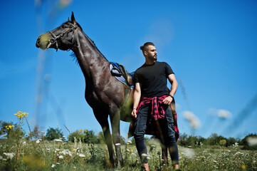 Arab tall beard man wear in black with arabian horse.